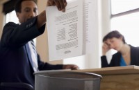 Businessman throwing away report into trash